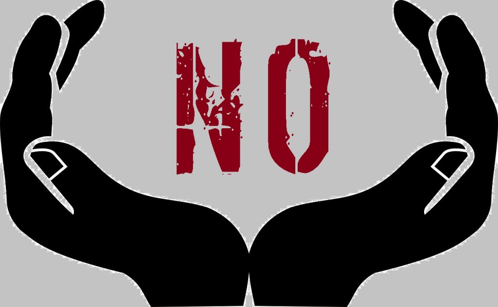 Image is clipart of a pair of hands held in a framing gesture with the wrists together. They are black against a gray background. The word NO is in red letters between them.