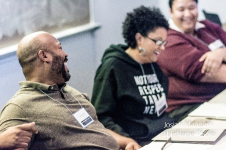 Photo of panelists laughing, Ashton Woods in the focus in the foreground.