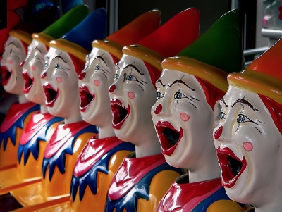 Photo of a line of plastic clowns with identical wide-open mouths.