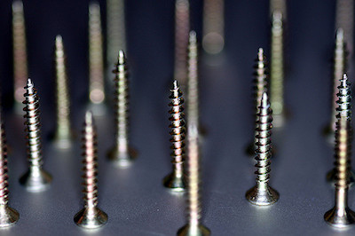 Photo of an array of screws balanced on their heads.
