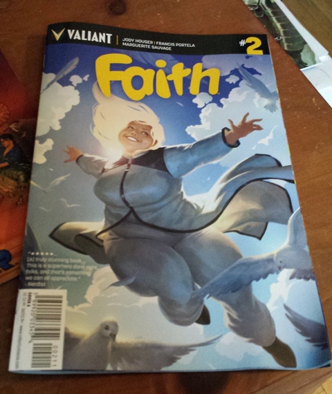 Image is of a comic book cover titled "Faith" #2. A woman in a white billowing suit is flying in the air, arms outstretched and hair blowing in the wind. In the background is blue sky and puffy white clouds, and there are white doves flying around the perimeter of the image, as though she's just flown throw a flock of them.