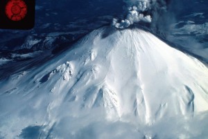 Image of Mount St. Helens's summit taken from an airplane. The summit has a small eruption plume rolling from it.