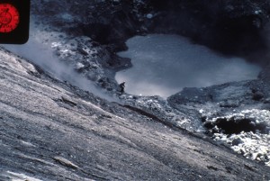 Image looks down into Mount St. Helens's crater. The tiny crater lake is now visible: it's basically a muddy pond. David Johnston has reached the edge.