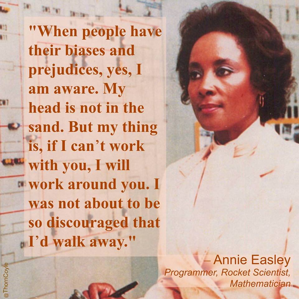 Image shows Annie Easley on the right. She is wearing a pink blouse, holding a pen, and looking thoughtfully towards the left. Caption on the left is a quote from her saying, "When people have their biases and prejudices, yes, I am aware. My head is not in the sand. But my thing is, if I can't work with you, I will work around you. I was not about to be so discouraged that I'd walk away."
