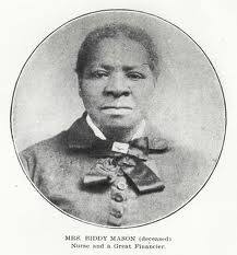 Image is an old black and white photo of an African American woman wearing a buttoned-up dress with a broad ribbon bowtie.