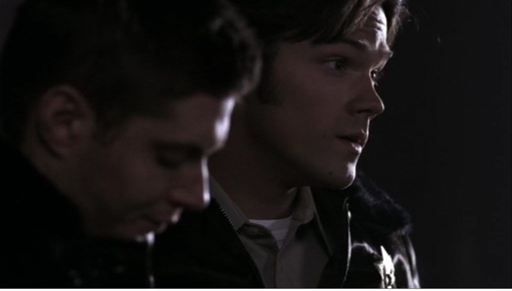 Screenshot shows Sam and Dean's faces clearly revealed. They are wearing brown state trooper uniforms.