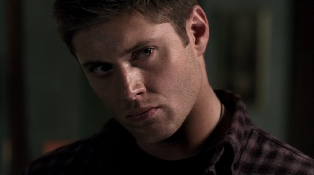 Screenshot is a close up of Dean's face. He has his head tilted to the side, and is frowning in a rather pouty way.