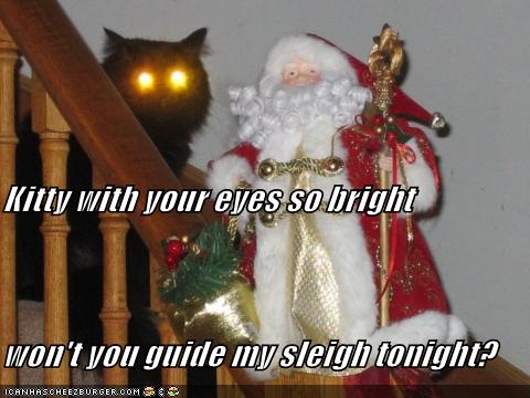 Image shows a Santa doll on a table. In the background, a black cat sits on the stairs and stares. The flash has turned its eyes into two huge gold orbs. Caption says, "Kitty with your eyes so bright, won't you guide my sleigh tonight?"