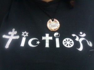 A t-shirt design reading "Fiction", the letters depicted by various religious symbols, along with a Surlyramics necklace showing the shape of a razor with the word "Occam' on it.