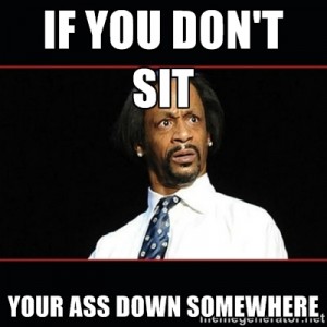Comedian Kat Williams in a white tshirt and blue tie, looking annoyed.  The meme captions says "If you don't sit your ass down somewhere"